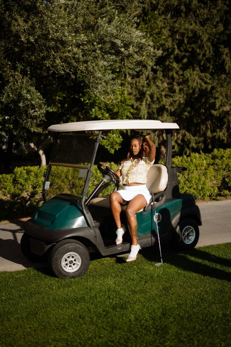 Person sitting in a golf cart on a sunny day